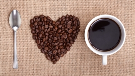 新鲜的心型咖啡豆拼图摆设与刀叉杯子