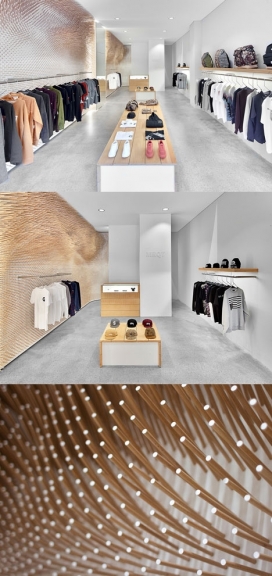 22,000质感木棍装饰的服饰专卖店-瑞士ROK建筑设计师打造-白色的墙壁和水泥地板与墙壁木棒形成强烈的对比