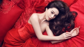 躺在华丽红色家纺床的亚洲女孩-范冰冰