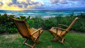 海洋天空旁边的两把木质摇椅