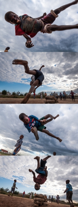 非洲小孩腾空跳跃的自娱自乐纪实摄影图
