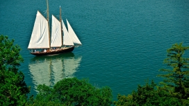 高清晰湖泊里的白色帆布船壁纸