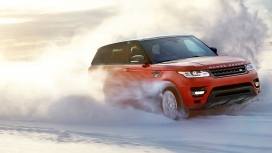 行驶在雪地中的高清晰红色路虎揽胜运动版SUV越野车