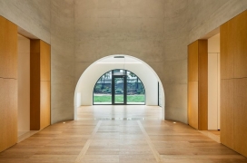 拱形开口的房子-灰色的砖墙正面，通过拱形窗户可以看到框架视图。