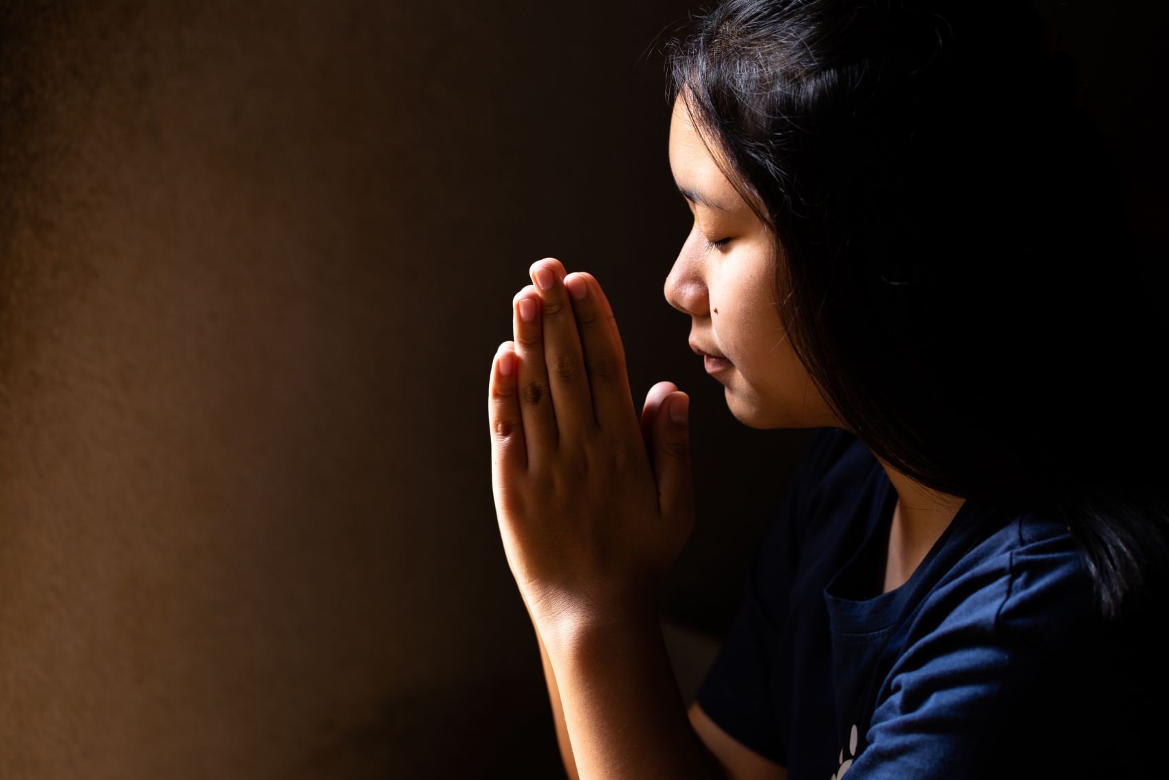 双手虔诚祷告的越南女子