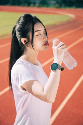 体育课后操场上喝水的女运动员