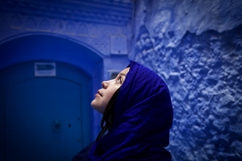 蓝色背景下仰拍的阿拉伯女郎
