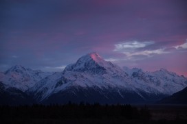 紫色天空下的雪山山峰图