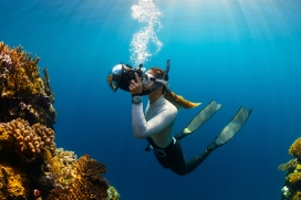 手持水下摄影机给珊瑚礁拍照的女摄影师
