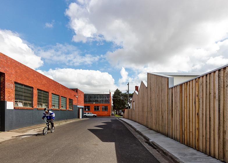 Profile House-坐落在澳大利亚墨尔本工业区,木墙上有三个小建筑物,周围有砖瓦楞铁仓库---酷图编号1