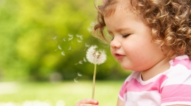 吹蒲公英许愿的金发女孩宝宝