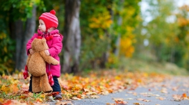 站在秋季公路上抱娃娃的婴儿