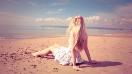 坐在沙滩上的金发美女