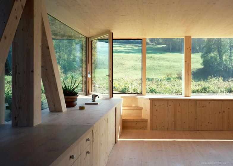 尖角木屋-木支架圆形窗口-位于瑞士北部麦田和树林灌木丛间,由当地建筑师Pascal Flammer设计,陡斜屋顶和飞檐,而且还集成了现代的元素,如全高玻璃和冲洗细节。---酷图编号19