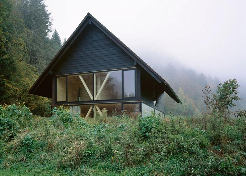尖角木屋-木支架圆形窗口-位于瑞士北部麦田和树林灌木丛间,由当地建筑师Pascal Flammer设计,陡斜屋顶和飞檐,而且还集成了现代的元素,如全高玻璃和冲洗细节。---酷图编号5