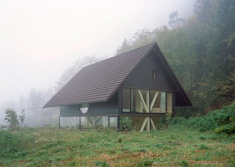 尖角木屋-木支架圆形窗口-位于瑞士北部麦田和树林灌木丛间,由当地建筑师Pascal Flammer设计,陡斜屋顶和飞檐,而且还集成了现代的元素,如全高玻璃和冲洗细节。---酷图编号2