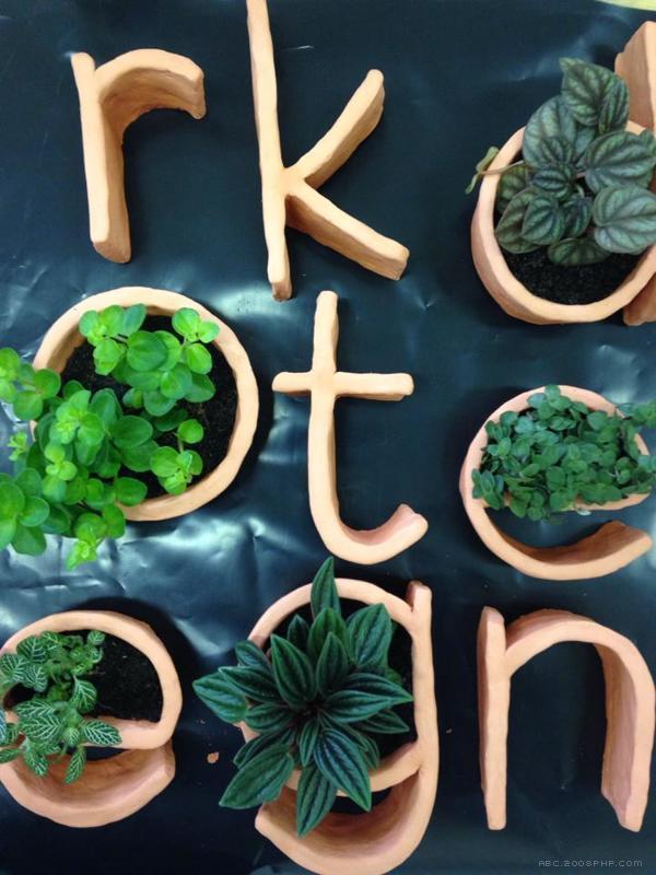 盆景字母设计-手工使用“原始橙”陶土和小植物制成---酷图编号1089392
