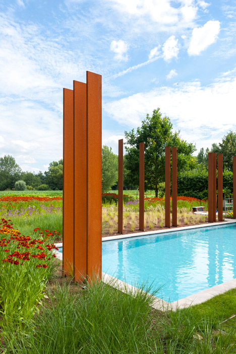 三层楼高的竖条木家-焊接金属板材料上穿孔,形成一个包层筛选,形成一个散热片,散热片横跨前置窗口延长到两个楼上,可保护其免受阳光和隐私的卧室---酷图编号1111206