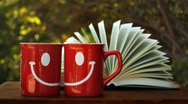 红色笑脸对杯与翻开的书本