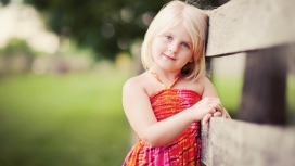 靠在木质栏杆上的金发女宝宝