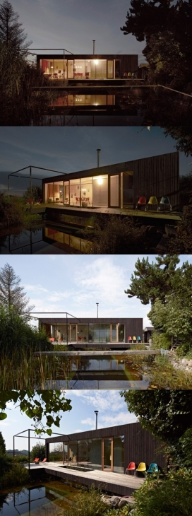 黑房子-位于奥地利的泥泞色调木房子，四个金属支柱，小型单层楼，仅有50平方米的面积，旁边有一个人工湖池塘，大窗户后可欣赏到湖光山色