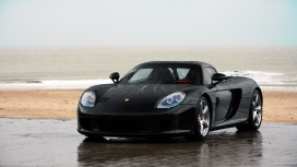 高清晰停靠在沙滩中的黑色保时捷卡雷拉GT（Carrera GT）壁纸下载