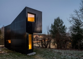 微型木材舱黑色别墅-倾斜的外墙。挪威工作室Jarmund/Vigsnæs建筑师作品。坐落在挪威首都郊区，只有15平米的结构。是一个安静的工作休息场所