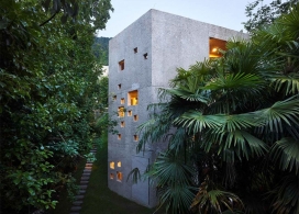 湖滨家-有三层高，粗糙的混凝土墙包围这所房子，旁边有一个陡峭的斜坡可以俯瞰瑞士的马焦雷湖