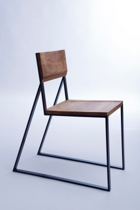 充满对比的K1的椅子-从侧面看它看起来像是一个细长线性的椅子，采用实心钢制木制的椅背。木材都采用有机天然谷物材料，搭配锐利棱角分明的线条金属框架。
