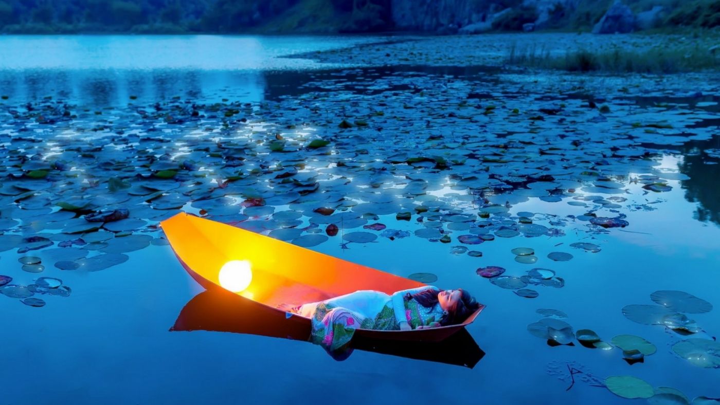 躺在湖中船休息的美女图片