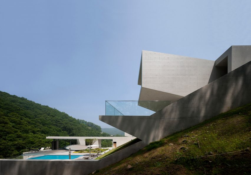 韩国度假胜地的山景别墅-从倾斜的位置向外推出,以确保最佳视野,折叠混凝土形式的清晰线条和倾斜角度与山谷形成鲜明对比,整体建筑采用戏剧性的风景设计,旨在增强建筑物与自然环境之间的联系。---酷图编号1173100