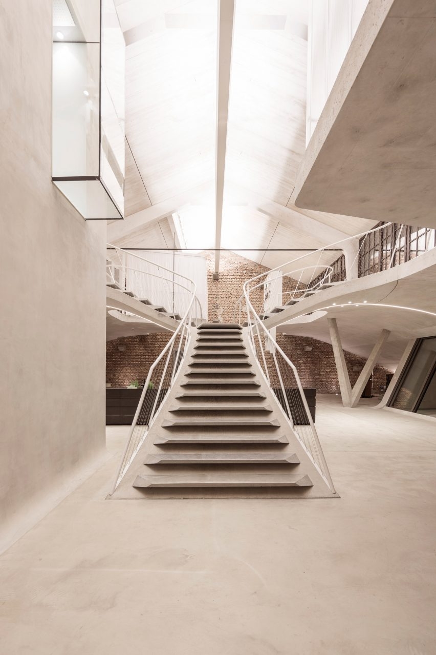 奥地利萨尔茨堡市旧萨尔斯堡坦克车站阁楼公寓的雕塑混凝土楼梯-占地350平方米,带一个玻璃淋浴间,悬臂悬挂在生活空间上,该建筑物已经转变为一个多功能场所,设有市场大厅,餐厅,水疗设施和两个合间。图片