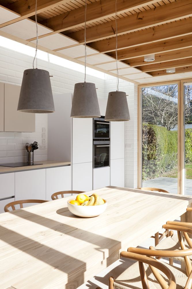 “林木”也是本次设计不可或缺的元素。房屋内部可以看到木质的建筑结构,木材还用于窗户框架的构建,甚至餐桌和室内挂件都是用原木或混凝土做成的。以平铺的地板和墙面为大环境,行走在木质的空间里彷如置身一场森林奇境。