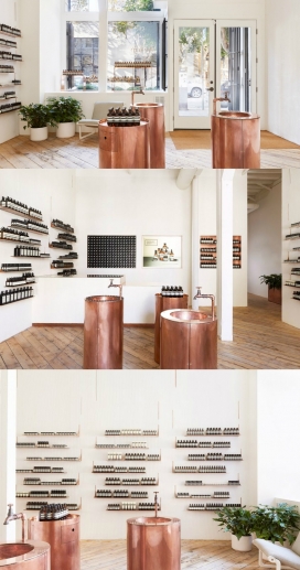 Tacklebox在旧金山威士忌仓库设计的铜口音护肤品Aesop商店-纹理石膏墙壁挂着一系列展示架，其表面上看起来像金属裂缝。其中两个是洗手盆，可以让客户测试不同的皮肤产品之后洗手，苍白的墙壁与粗糙的木地板配对，使得看上去轻便审美