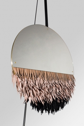 Laz通过工艺在一面镜子前展示拜物和奢侈品之间的关系，允许人们表演他们的幻想