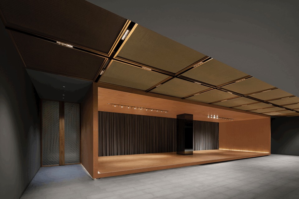 空间的色调和材质采用偏暗的灰色和木色,材质选用了樱桃木和香槟金色金属网。灰色的墙面衬托出两种材质的光泽,BOX 是空间中的造型特点,基本上由木头材质体现。背景的空间由大面积的灰色做衬底。在活动区的顶部、静廊和冥想区采用了金属网。金属网材质即通透又有光泽,在空间中若隐若现。不仅增加了空间的层次,也创造了更深一层的空间内涵。