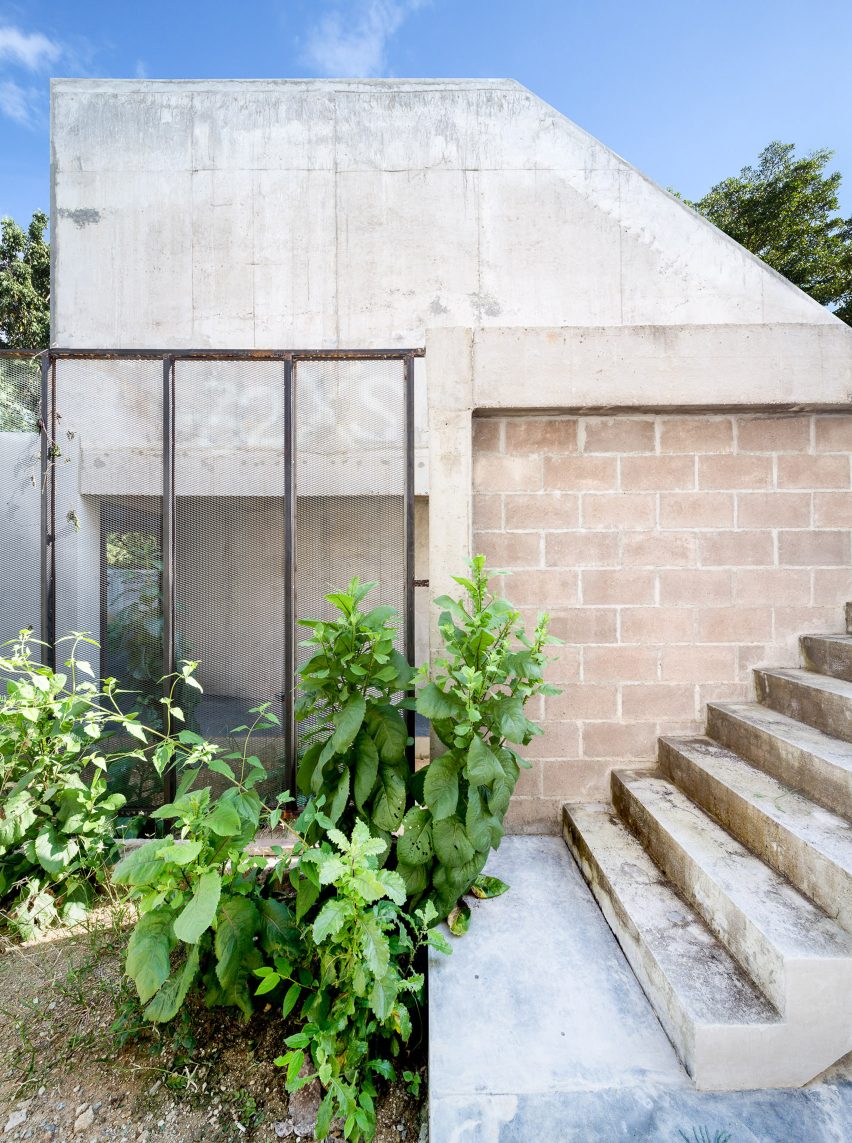 在一端是一个车库的开口,而路径通过一片杂草朝向延伸穿过整个场地的一条小巷,生活区上方的天花板呈阶梯状,形成了屋顶露台,客人可以通过前院放松身心并观看。