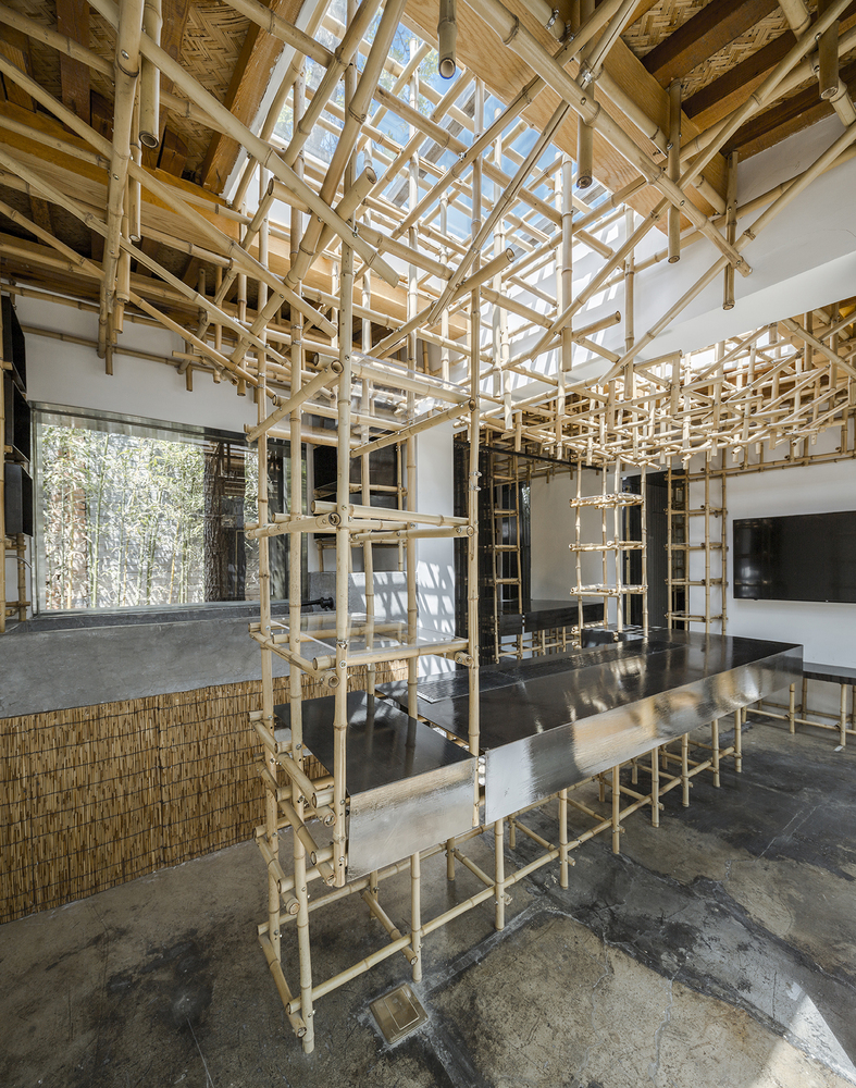 竹子是用现代装配式的手法用螺丝全部固定在一起,并形成具有结构作用的整体体系。利用钢板,铁丝窗帘,玻璃作为辅助材料把整个空间关系变成实体、半透明、透明相互穿插的空间