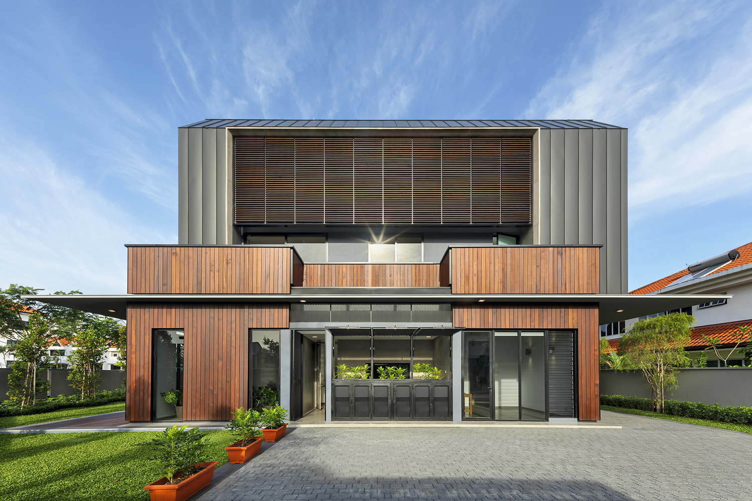 房屋内的空间以一种理性且经过深思熟虑的方式组织起来,有良好的比例和舒适的居住空间,尽可能最大化自然采光和通风。宽大的木质隔板进一步帮助调节周围环境,提供了遮阳和额外的私密空间,同时也能屏蔽来自主路上拥挤的交通造成的噪音和灰尘。