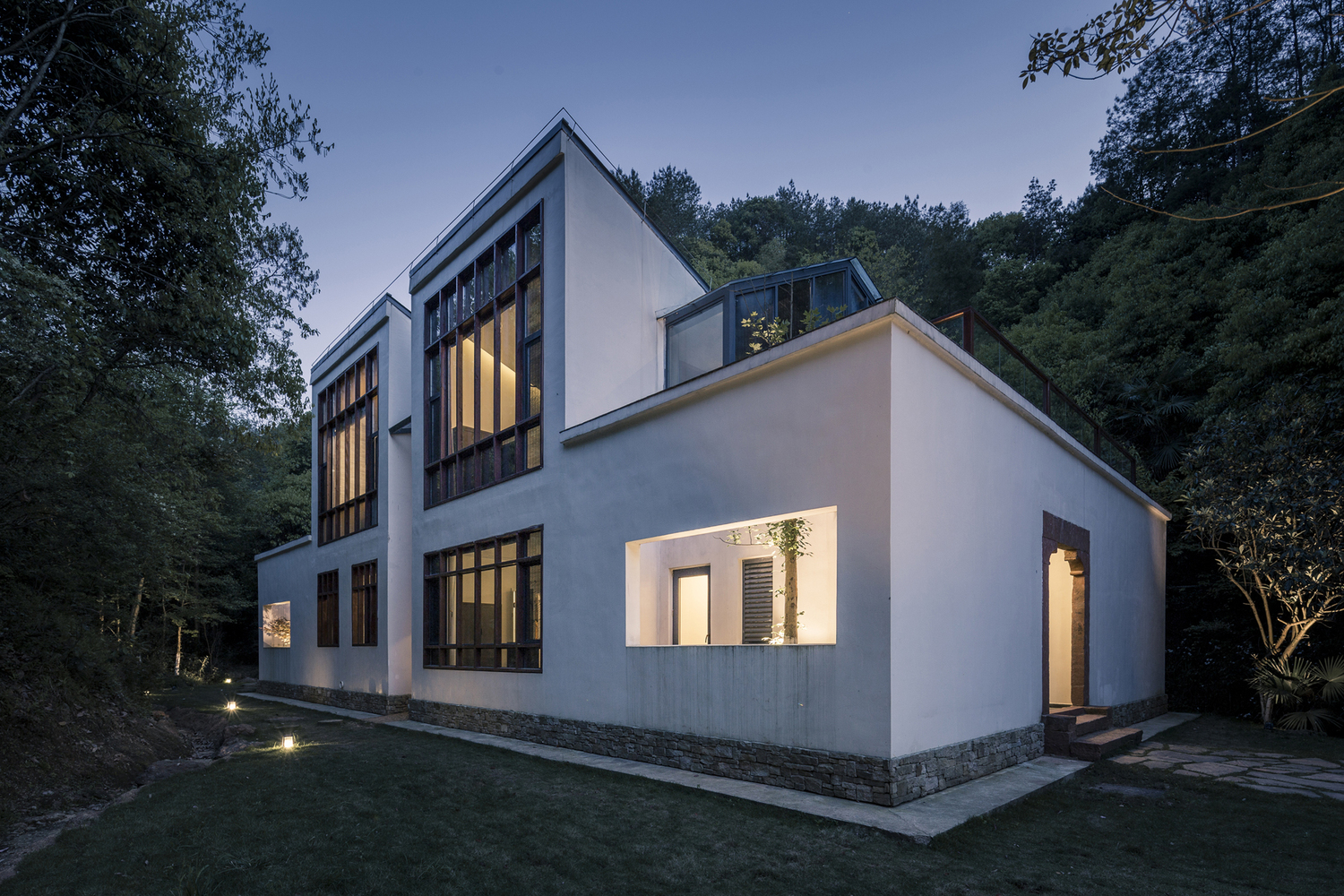 另一方面,在建筑的风格样式上,双溪书院的建筑是运用现代的建筑材料和结构技术来体现地域传统建筑意向的尝试。从内天井的结构布局,到木构构架与高耸的白墙,连续的灰瓦坡顶,到石、木、瓦等材料肌理,这些建筑设计的形象生成既来源于当地的传统民居建筑,同时也是对更广义的中国南方民居的建筑符号的片段提取和抽象提炼。在建造上,除了常规的混凝土框架作为基础结构,还使用了大量的竹钢,铝板金属屋面,和一部分GRC(玻璃纤维加强混凝土)材料,这些材料的组合也对施工工艺提出了新的要求。在风格上,双溪书院的七个单体建筑,总体有相似的元素,但又因山势而样貌迥异,各有特点。