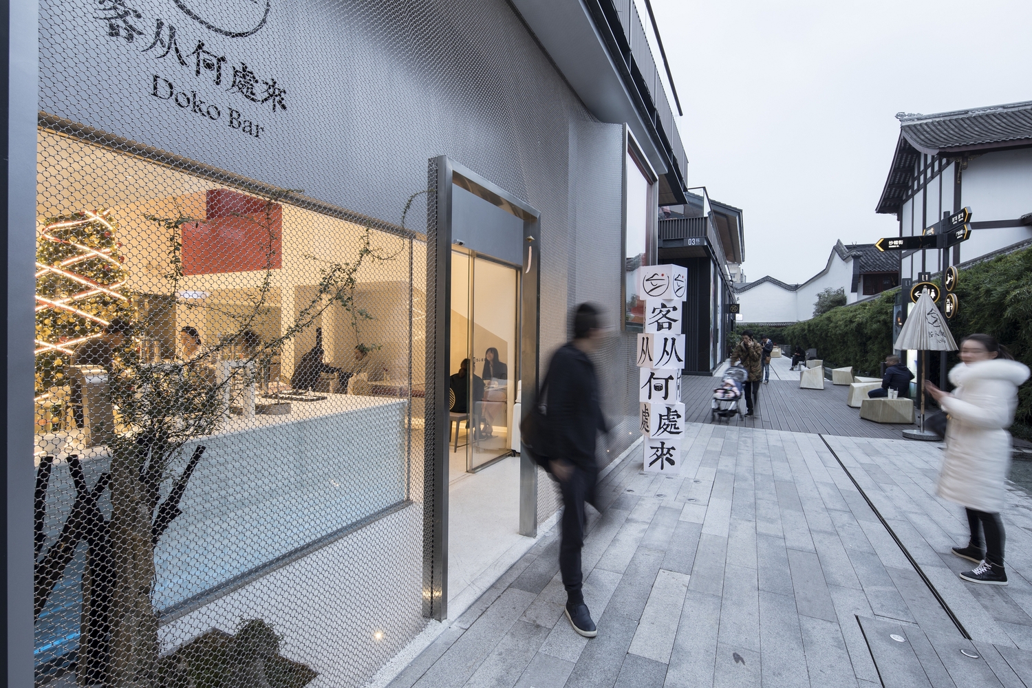 我们从大正昭和年间的色典中选出较低饱和度的红“珊瑚珠”作为贯穿一二层交通的色彩,与对面的寺庙红墙产生对话。室内共两层均层高较高,且原始条件两层之间无楼梯连接。这些现状给设计和布局留下了更大的空间和余地,因此交通空间的设计成为此次改造的一个重点。通道由剪刀梯,夹层平台和无柱旋转楼梯组成。玻璃砖与珊瑚珠色钢板组成的交通空间串联着几处可停顿空间,使游走过程因此慢了下来,缓解因层高造成的令人恐惧的楼梯踏步数量,并丰富了体验内容。