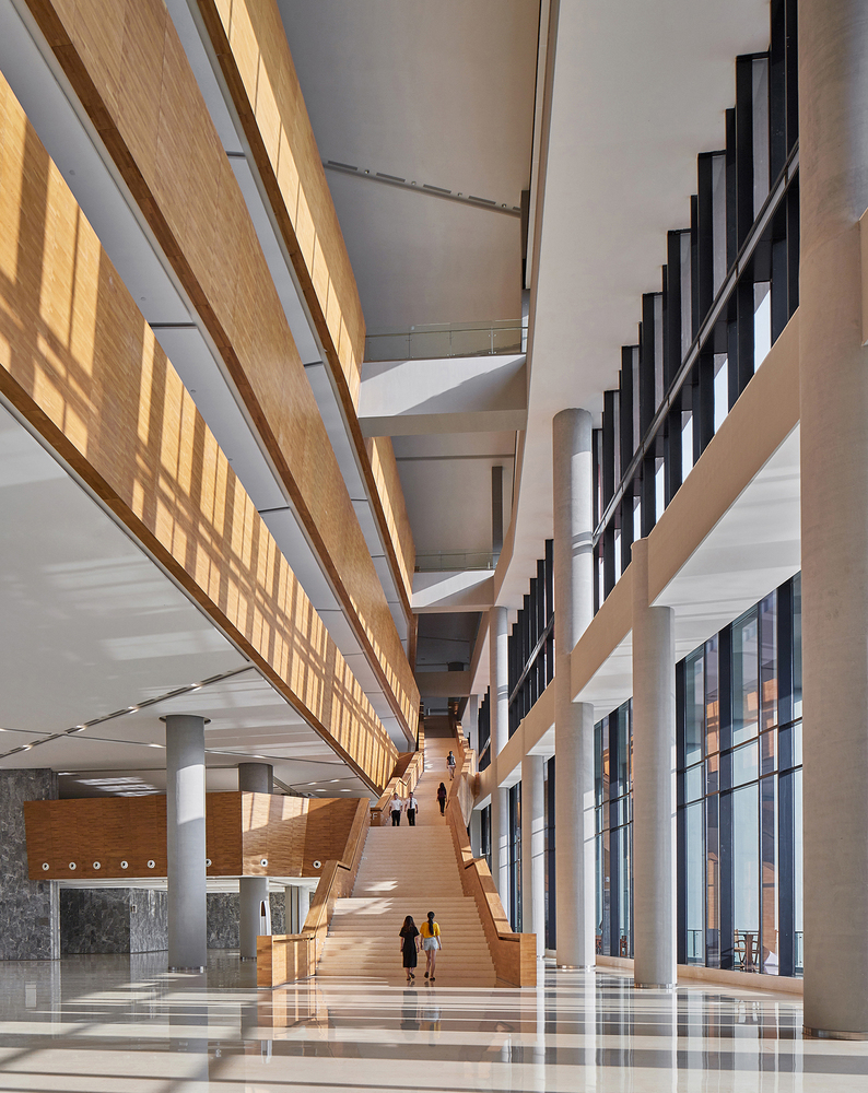 顶层办公挑高的空间体量被充分利用,增建了局部夹层空间以形成不同的场景氛围。几个张拉膜结构的白色巨伞将照明灯光柔和地漫射到每一个工位,成为了空间造景的视觉焦点。