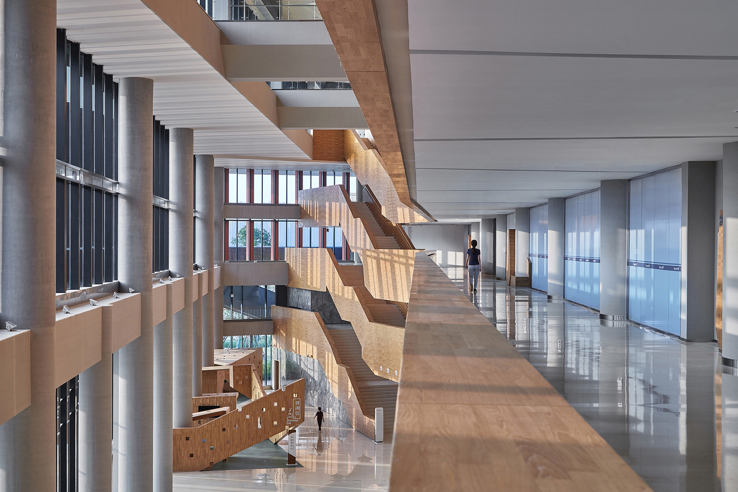 为了进一步强调人、建筑与自然之间的互动体验,办公楼内沿湖一侧设置了一个贯通整个楼层、被称为“大峡谷”的巨型中庭空间,这里是众多角度下视线的焦点,它的设置将湖景天光引入到建筑内部,室内与室外在视觉元素上达成了高度统一。这里体现了腾讯公司文化理念中交汇融合、自由开放的精神。中庭空间周围折线的楼板和围栏造型呼应了外部建筑的形体语言,装饰与建筑也自然而然地协调统一起来。