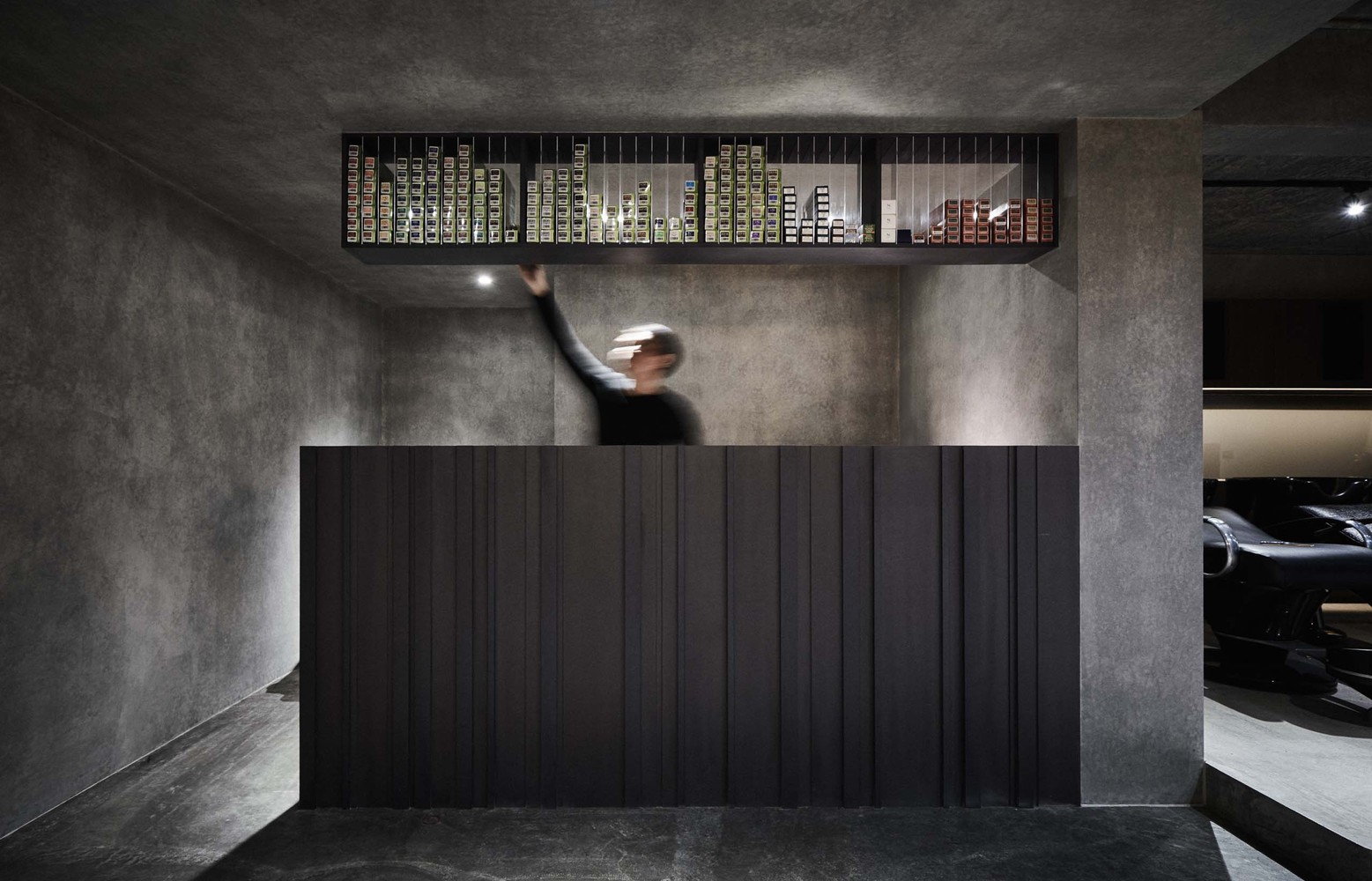 整体形象以俐落的线性剪裁贯穿,由入口立面对应到木质门把再由接待柜台延伸至隔屏,以垂直的斜切面呈现,使得外部视觉不容易直视内部,并透过反射感较为模糊的金属材质提高物件柔和的轻盈感,让面积较大的固定物件经过裁剪后的排列,在空间中保有流畅的穿透性。