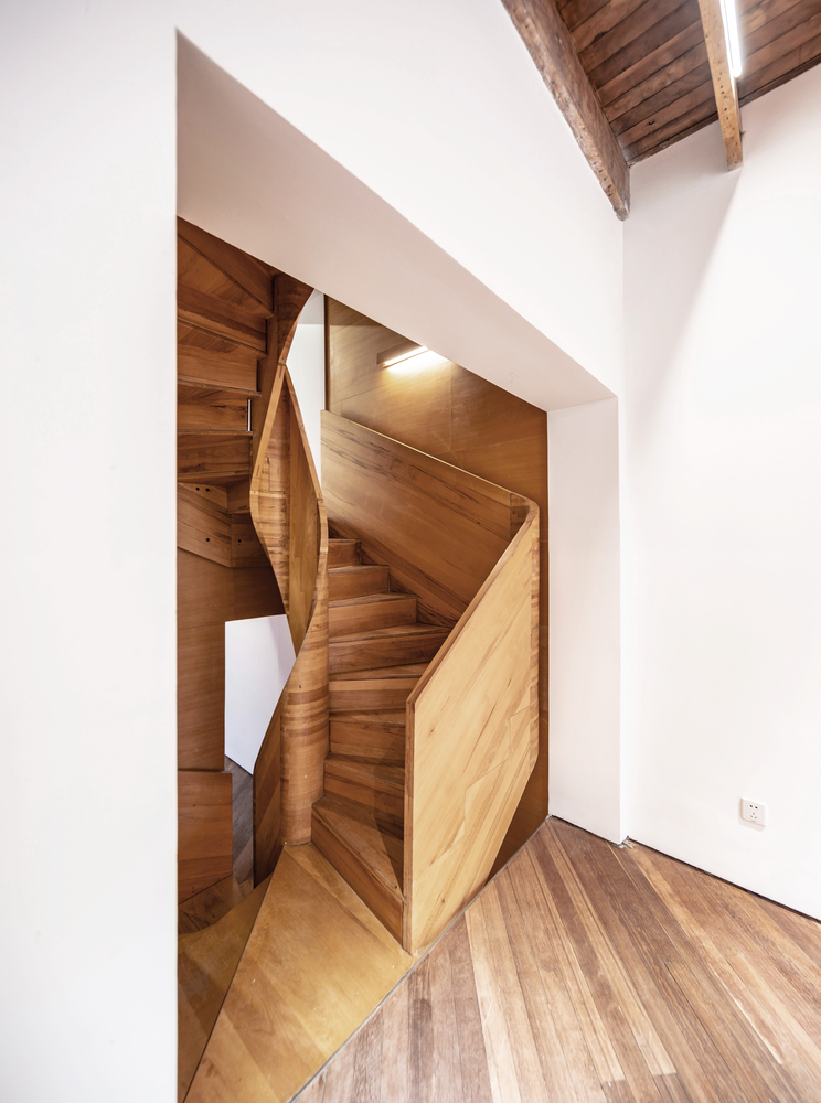 进一步,楼梯间墙壁的榉木贴皮使整个楼梯间呈现了一种均匀的质感,而这种直达顶层的连续体验又被楼梯间里各种开洞刻意打断,我们通过开洞拼贴入临近的空间感知:在楼梯间顶部增加天窗,改变空间的开门位置,尽量扩大门洞,增加朝向楼梯间的窗洞。让光从不同的房间折射进楼梯间,明暗交织,将垂直的楼梯间变成一个产生视线交流的中庭,以获得类似东方园林廊道的空间质量。结合流线的转折,视线的“藏与现”中,同样面积的空间中的体验更丰富了,房子似乎也被放大了。