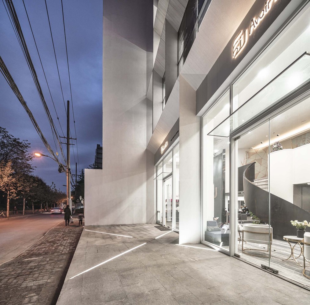 设计上希望赋予建筑“P.U.R.E.”的气质(P:peaceful静谧,城市中的一处静谧之处;U:urban城市,城市为背景;R:regeneration改造,赋予旧建筑新面孔;E:ecology生态)。让自然融于建筑,极简的形体、纯白的色彩、简单的构造,回应了嘈杂与喧嚣的周边城市环境,营造城市中的一处静谧之地。外墙主墙面采用白色无机饰面砂浆,打造纯净安静的气质;通过其表面的纹理及颗粒感,凸显精致细腻的高品质形象,赋予建筑新面孔。大面积的开窗将自然光引入室内,营造舒适明快的室内空间,同时可以更好的感知到北侧的华山绿地,将自然溶于建筑。