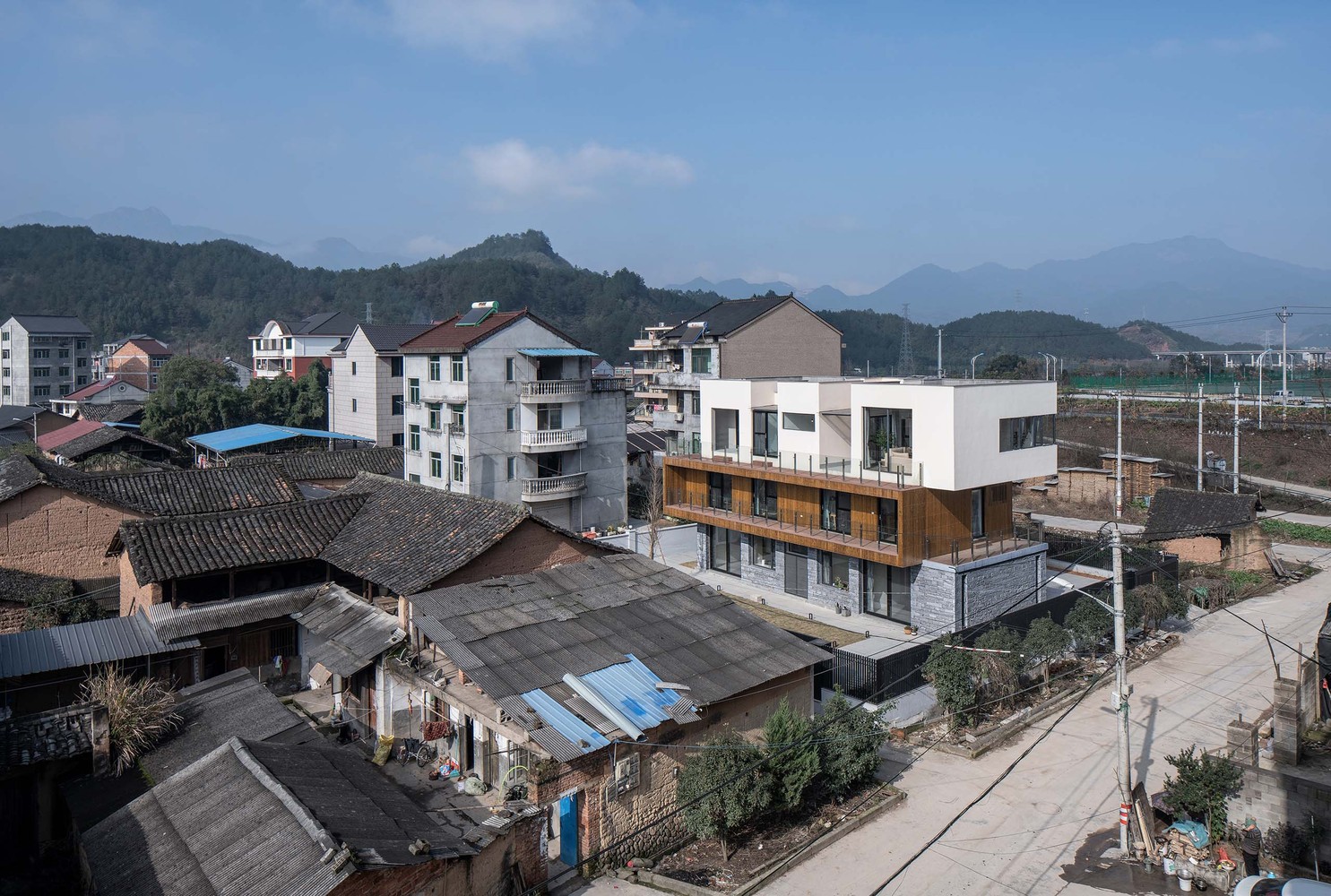 首层作为共享空间,朝向南北两个庭院开敞的起居室是视觉的起点,穿过玄关和楼梯,配有独立中西厨房的餐厅是视觉的终点;二层作为居住空间,两个居住套房均布置有书房、衣帽间和独立卫生间,并共享了南侧长达18米的阳台;顶层是业主的私人办公与生活空间,自带庭院的工作室和配有健身房的独立套房通过L型的露台建立了室外空间的联系,北侧的庭院设置了一部旋转楼梯可以到达屋面。