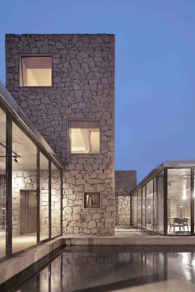 创造性与“接地气”有关,中国古话叫做“天时地利人和”,对于这座被彭乐乐自己叫做“红石山房”的低成本小型建筑,它的创造性得益于此时(天时)此地(地利)此心(人和)。所谓此时,就是中国所有的现、当代文化和建筑,是经历了一百多年向西方现、当代文化学习的过程,在这个过程中,经历了中国传统文化与西方文化的碰撞、矛盾,以及借西方文化重新认识,和转换中国传统文化和建筑因素这个历史的交结点上,即它意味着近三十多年来,在大规模的城市化过程中,所积累的建筑上的弊病,诸如随处可见的水泥森林模式,耀眼的玻璃和金属光芒,以及对欧美现、当代建筑模式的抄袭和拼接所形成的审美“疲劳”,人们希望看到“接地气”并有创造性的当代建筑。事实上,近若干年诸如日本建筑师西泽立卫、隈研吾等人转换东方传统建筑的有创造性的试验。去年获得普利策奖的印度建筑师巴克里希纳.多西,他把早期西方学习的背景和本土文化相结合,发展出与其自身历史、文化以及本土传统相关的现代建筑语汇。乃至中国年轻的建筑师在理论和实践上也都取得一些“接地气”的经验和成就,如张永和较早试尝试做夯墙建筑的试验成果,王澍对中国传统建筑的研究和实践,当然还可以举出很多这样的例子,或者说在现代、当代建筑的全球化过程中,接受欧美现代当代建筑文化的营养的同时,注意研究并在建筑实践中转换自己传统文化和建筑因素,强调因地制宜,在中国乃至整个欧美之外的地区,已经蔚然成风