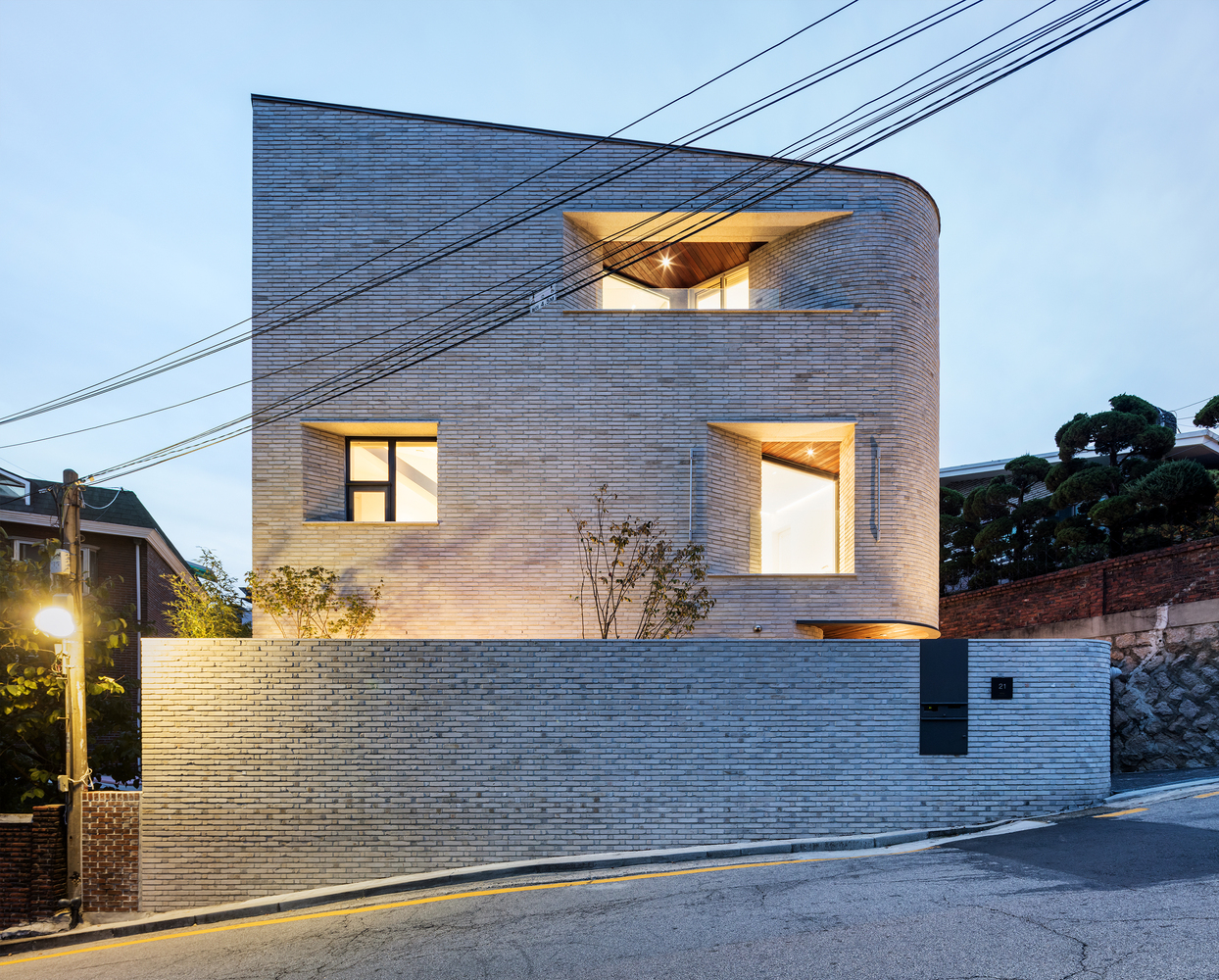 克制的线条,或锐或钝的角隅,环形,和斜线这些几何细节塑造了住宅的庄重感,也给观者带来了平静而具有活力的双重感觉。在两条通道相交的路口附近,是一个稍成曲状的弧形边缘,和对面角状的高台形成对比,为走向不同方向的路程带来不同的体验