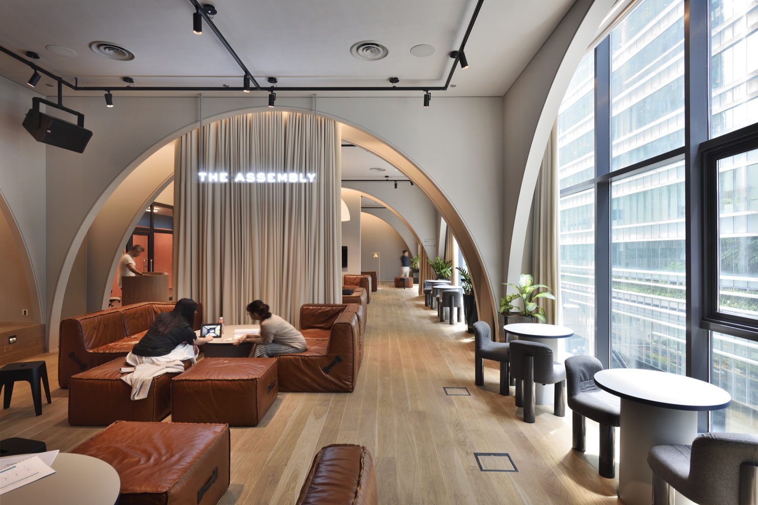 新的联合办公空间优雅地坐落于建筑的混凝土立面之内,轻轻覆盖又没有完全遮蔽,宛如大楼的第二层皮肤。建筑师在材质处理上采用了“尊重和保留朴素的原始建筑表皮”的方式,室内局部墙体外露,采用胶合板饰面进行造型,整体铺设橡胶地面。再加上设计采用的动态的、色彩多变的分色玻璃,低调精致的设计细节,还有 The Working Capitol 联合办公品牌标志性的蓝绿色元素,整个办公空间营造出优雅而俏皮的都市体验。